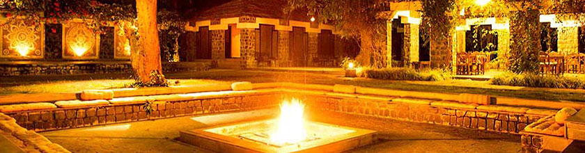romantischer Innenhof der Bandhav Vilas Lodge mit Lagerfeuer am Abend